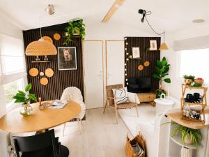 a living room with a table and a tv at The Red Shutter Cottage in Hattemerbroek