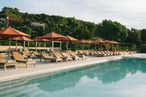 a swimming pool with lounge chairs and umbrellas at The Lodge Mallorca, Small Luxury Hotels in Sa Pobla