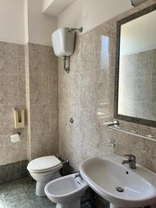 a bathroom with a sink and a toilet and a mirror at Hotel Ludovici in Fiuggi