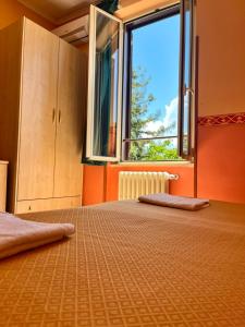 a bedroom with a bed with a large window at Hotel Ludovici in Fiuggi