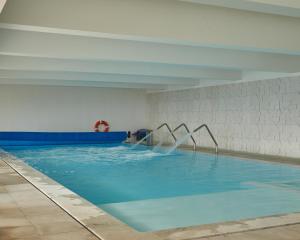 a swimming pool with blue water in a building at Alfândega da Fé Hotel & SPA in Sambade +30 photos
