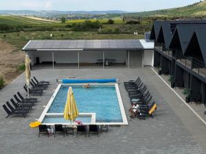 an overhead view of a swimming pool with chairs and umbrellas at La Luna Imobiliare in Ocna-Mureşului