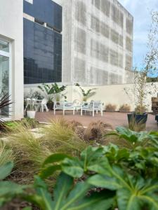 a courtyard with white chairs and a building at Pedra de Sal Hostel & Suites in Rio Maior