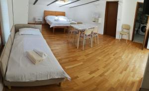 a bedroom with two beds and a table with chairs at Rose in Portorož +29 photos