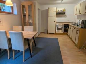 a kitchen and dining room with a wooden table and chairs at Ferienwohnung Tammer Allee in Tamm