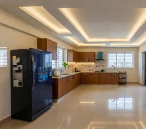 a large kitchen with a black refrigerator in a room at Royal Richmond Hotel in Dhaka