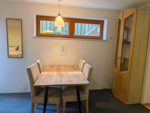 a dining room with a wooden table and chairs at Ferienwohnung Tammer Allee in Tamm
