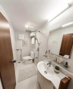 a bathroom with a sink and a toilet and a mirror at Royal Richmond Hotel in Dhaka +35 photos