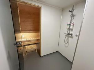 a bathroom with a shower with a wooden door at Hedvig Guesthouse & Ragnahus in Bugøynes +96 photos