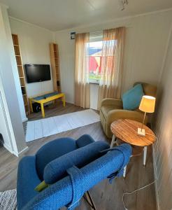a living room with a blue couch and a table at Hedvig Guesthouse & Ragnahus in Bugøynes