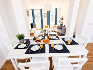a white dining room with a white table and chairs at Centre-Ville Appartement 90m2 Le Normand in Elbeuf