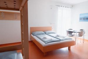 a bedroom with a bed and a desk and a table at Junges Hotel Hard am Bodensee in Hard