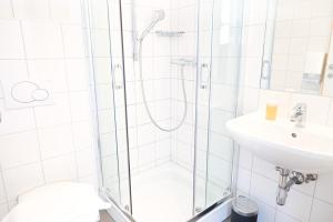 a bathroom with a shower and a sink at Junges Hotel Hard am Bodensee in Hard