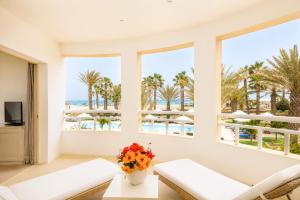 a living room with windows and a view of the beach at Hotel Morabeza in Santa Maria