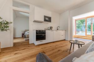 a white living room with a kitchen and a table at Hakuna Rooftop Penthouse Wachau in Spitz
