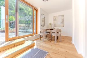 a dining room with a table and a large window at Hakuna Rooftop Penthouse Wachau in Spitz