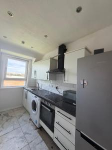 a kitchen with a washer and dryer in it at Glasgow Airport in Glasgow