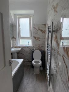 a bathroom with a toilet and a tub and a sink at Glasgow Airport in Glasgow
