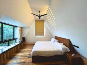 a bedroom with a bed and a ceiling fan at Mangalath River View Resorts in Kodanad