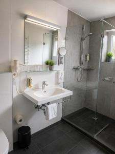 a bathroom with a sink and a shower at Lieth-Hotel-Grünreich in Bad Fallingbostel +203 photos