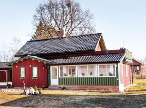 a red and green house with people sitting in front of it at Dalälven Strand in Södersätra