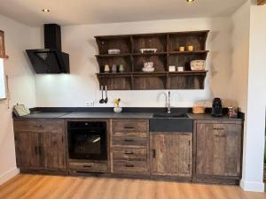 a kitchen with wooden cabinets and a sink at Sea Cottage in Westerland +10 photos