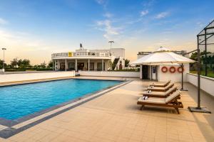 a swimming pool with chairs and an umbrella next to a building at KMR Hotels & Resorts in Bikaner