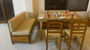 a dining room table with chairs and a table and a bench at The King's Hotel in Tuticorin +32 photos