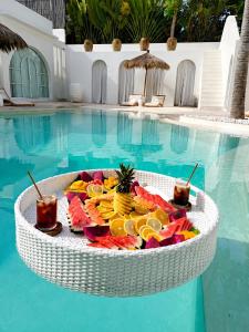 a tray of fruit on a table next to a swimming pool at MAJA Canggu in Canggu