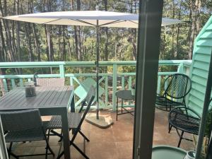 a patio with a table and chairs and an umbrella at La Perle des Pins LACANAU OCEAN in Lacanau