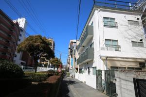 a white building on the side of a street at QU302 EPrivate 2BR Home with Living Room and Kitchen, Separate Bath and Toilet, Sleeps 4 in Tokyo