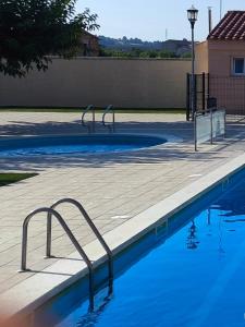a swimming pool with blue water and metal rails at El Clos 2 in Conesa