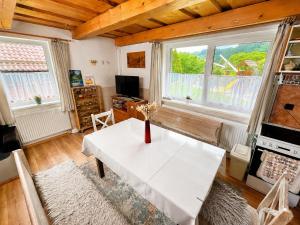 a living room with a white table and two windows at Chata u pltníka Paľka in Podbiel