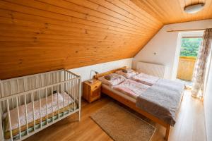 a attic bedroom with a bed and a window at Chata u pltníka Paľka in Podbiel