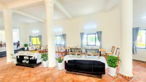a living room with columns and a table and chairs at Sun resort & villa beach in Tiến Thành