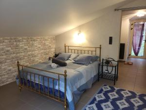 a bedroom with a bed and a brick wall at Gîte du grand braquet in Puget-Théniers
