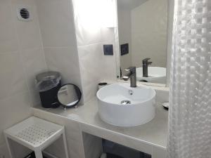 a white bathroom with a sink and a mirror at Gîte du grand braquet in Puget-Théniers +8 photos