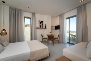 a hotel room with two beds and a table and chairs at Elpis Studio Apartments in Bali +112 photos