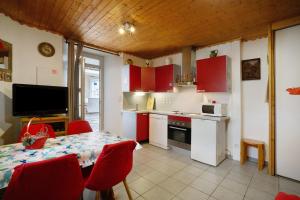 a kitchen with red cabinets and a table with red chairs at Studio cabine - Les ecrins 2 in Valloire +10 photos
