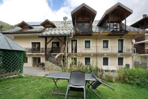 a table and a chair in front of a house at Studio cabine - Les ecrins 2 in Valloire