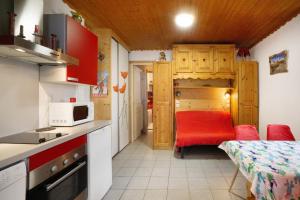 a small kitchen with a red chair in a room at Studio cabine - Les ecrins 2 in Valloire