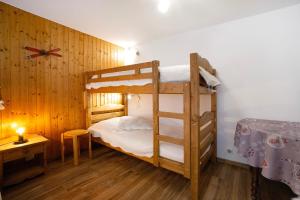 a bedroom with two bunk beds and a desk at Appartement - Les ecrins 3 in Valloire