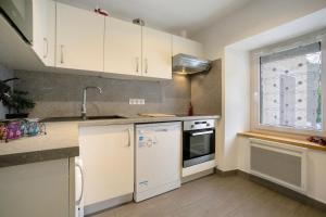 a kitchen with white cabinets and a window at Appartement - Les ecrins 3 in Valloire