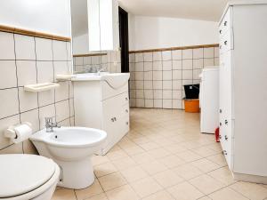 a white bathroom with a toilet and a sink at MANSARDA COSTA BIANCA - Free Parking in Realmonte