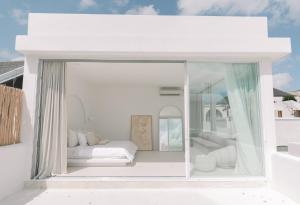 a white room with a bed and a window at MAJA Canggu in Canggu