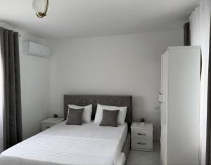 a bedroom with a bed with white sheets and pillows at Rodon Blue Villa in Shetaj
