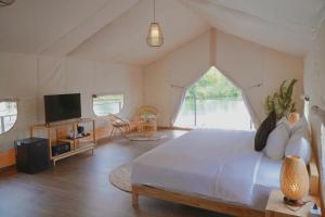 a bedroom with a bed and a tv in a room at La Vela Legacy Resort in Thôn Dương Xuân Hạ