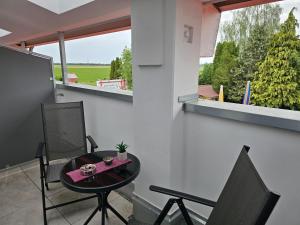 a small table and chairs on a balcony with a window at Hotel Felix in Mietingen