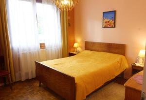a bedroom with a bed and a window and a chandelier at Charmante maison Corisande in Gerde
