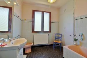 a bathroom with a sink and a tub and a toilet at Charmante maison Corisande in Gerde +8 photos
